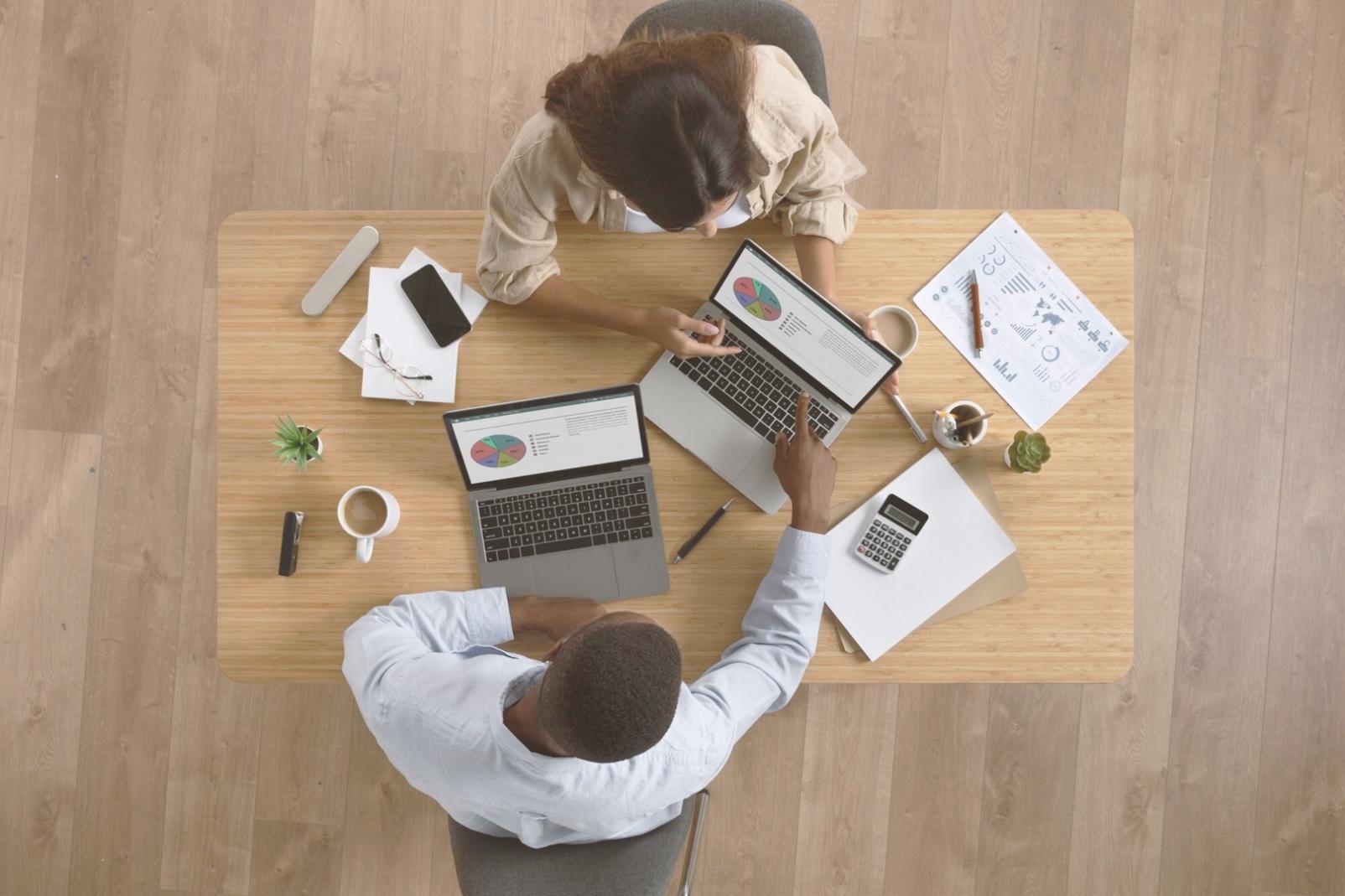 Persona organizando documentos financieros en un escritorio moderno, mostrando el proceso sistemático de planificación presupuestaria