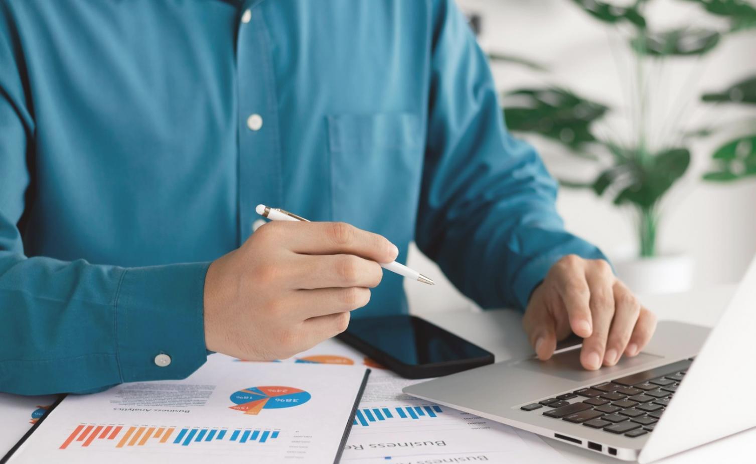 Persona trabajando en planificación financiera con documentos y calculadora